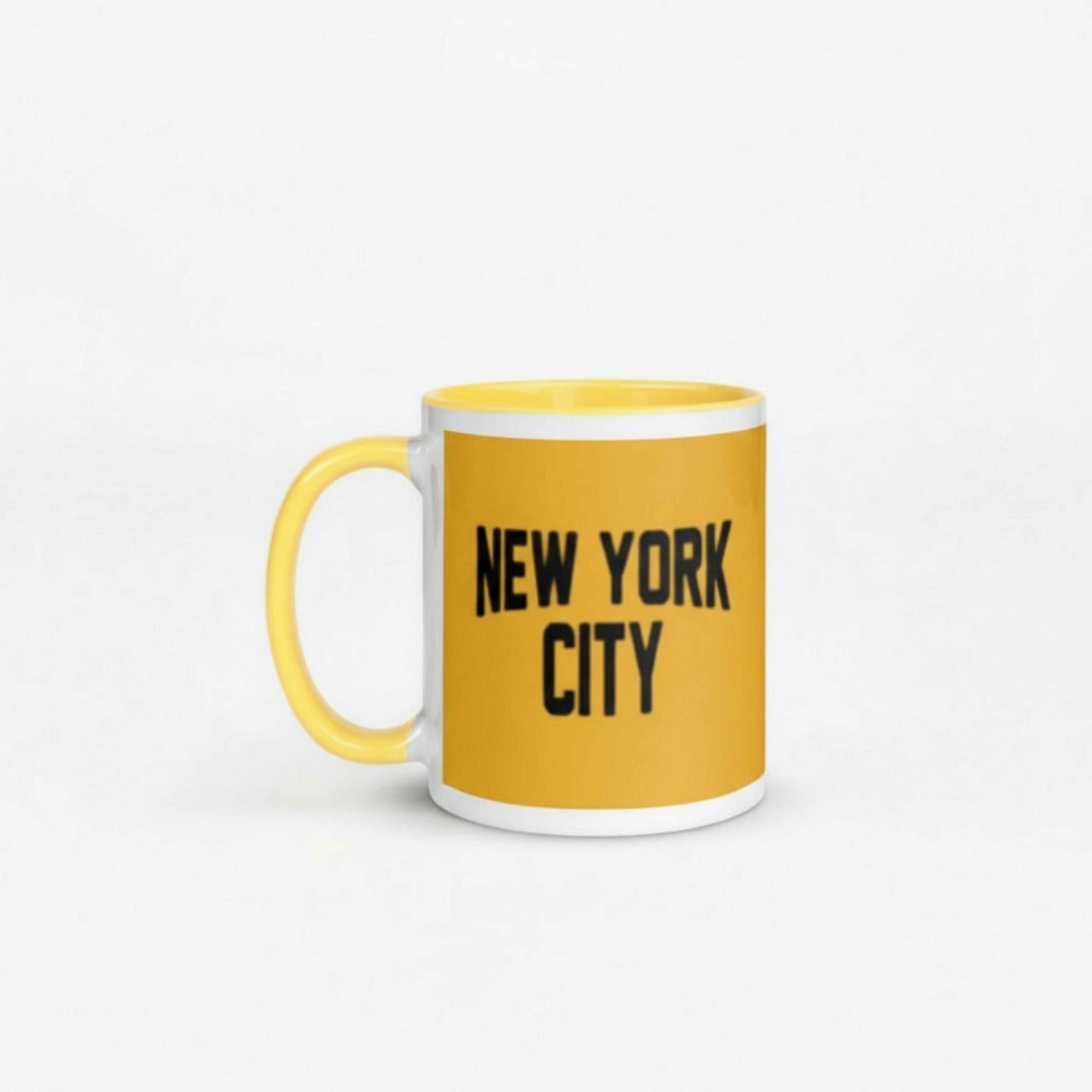 Yellow mug with 'New York City' text on a white surface with Christmas decorations.